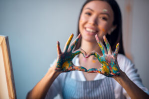 Happy girl with paint on hands