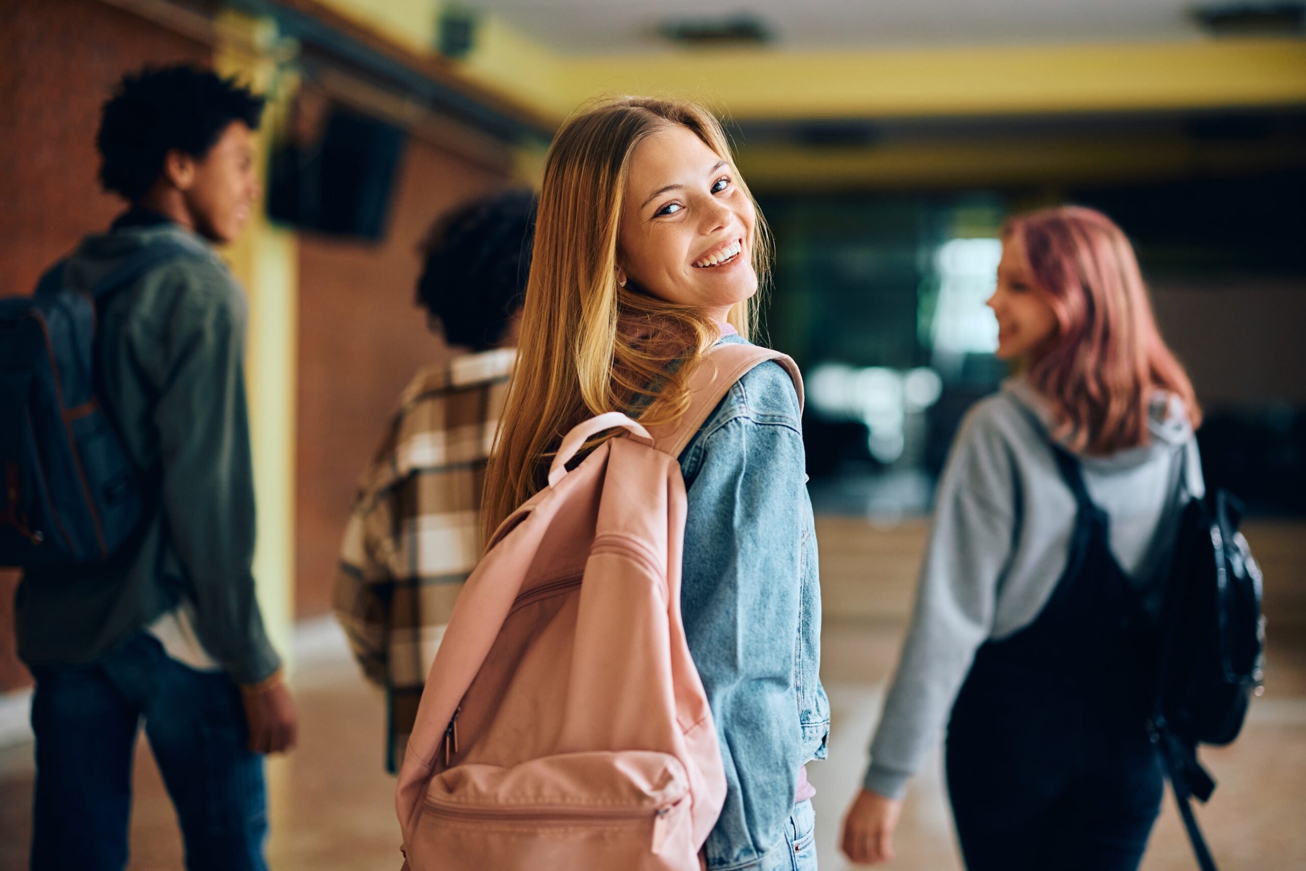 Happy,Teenage,Girl,In,Hallway,At,High,School,Looking,At