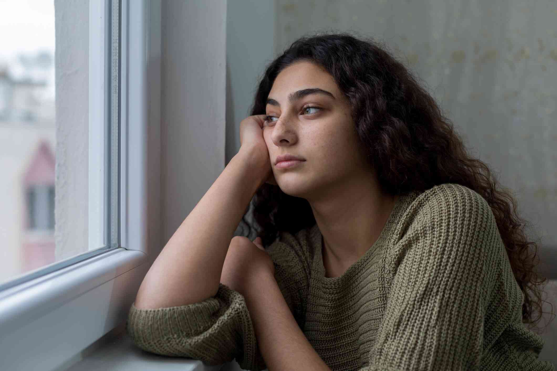 teen girl gazing out window