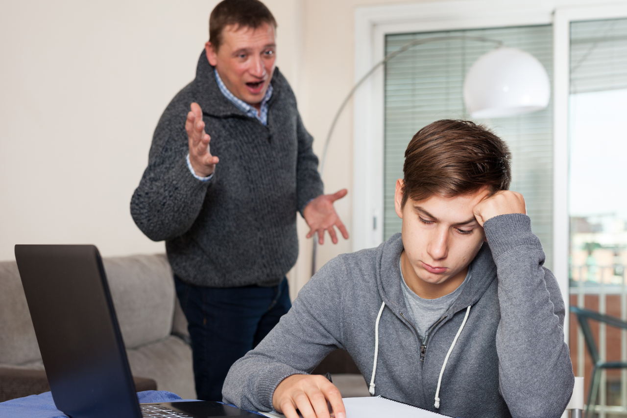 father standing over his child showing what it is to be a helicopter parent