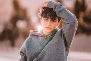 young male teen standing outside wondering when is a teens brain fully developed