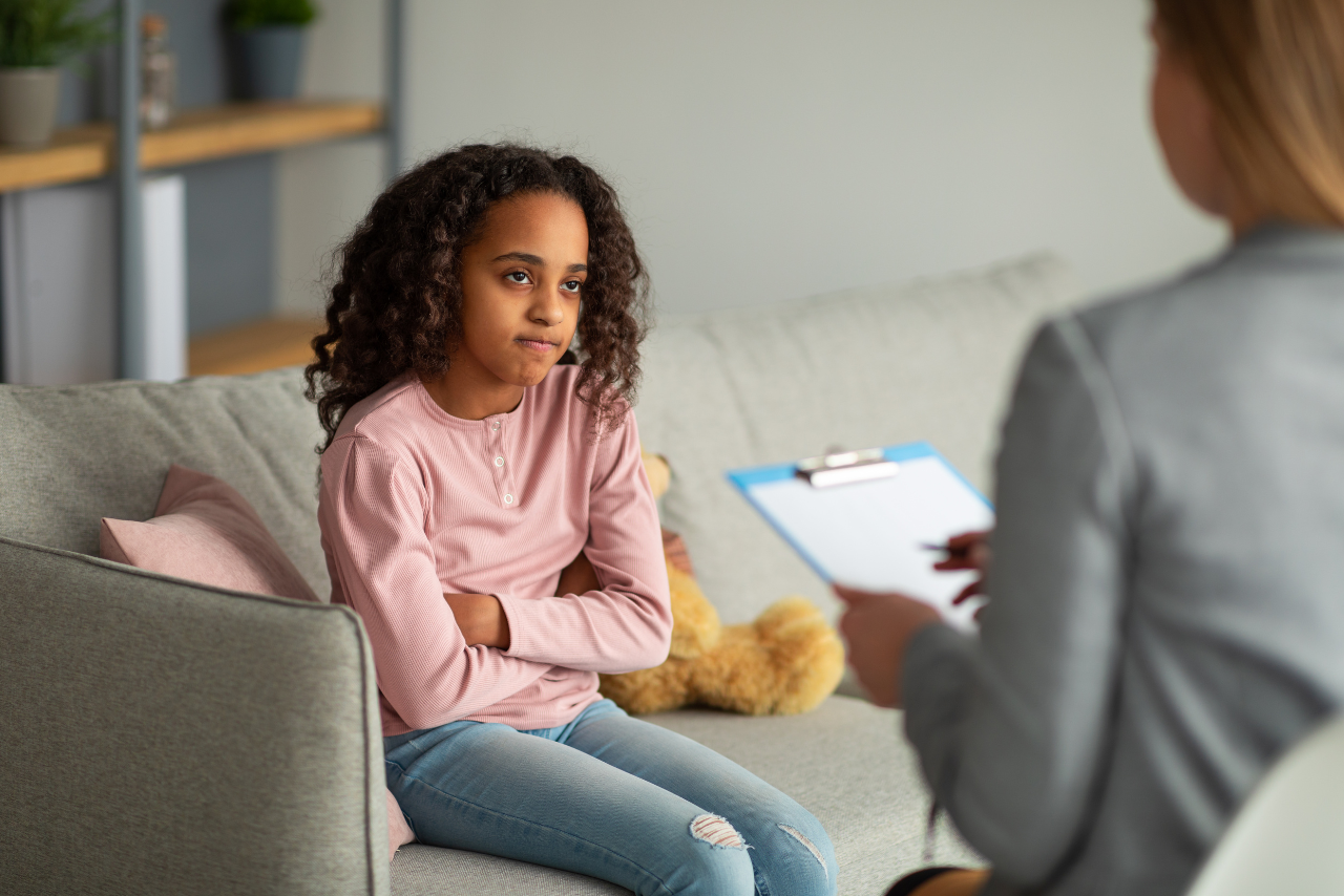 young teen girl speaking with her therapist after showing signs of risky behavior in adolescence