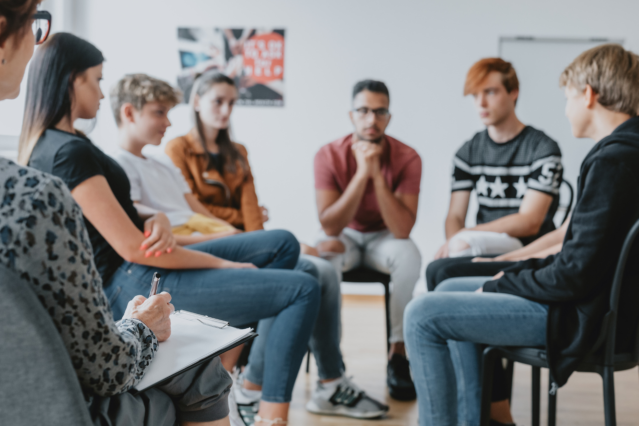 group of teens in therapy discussing teen brain development