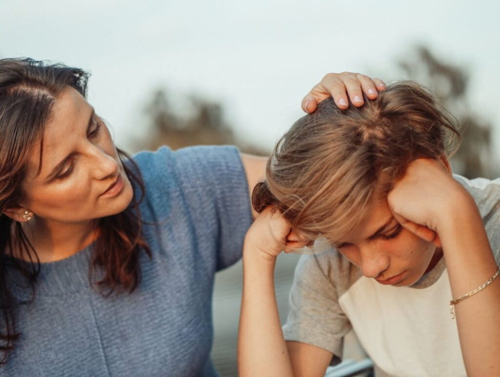 mother helping teenage boy resolve conflict