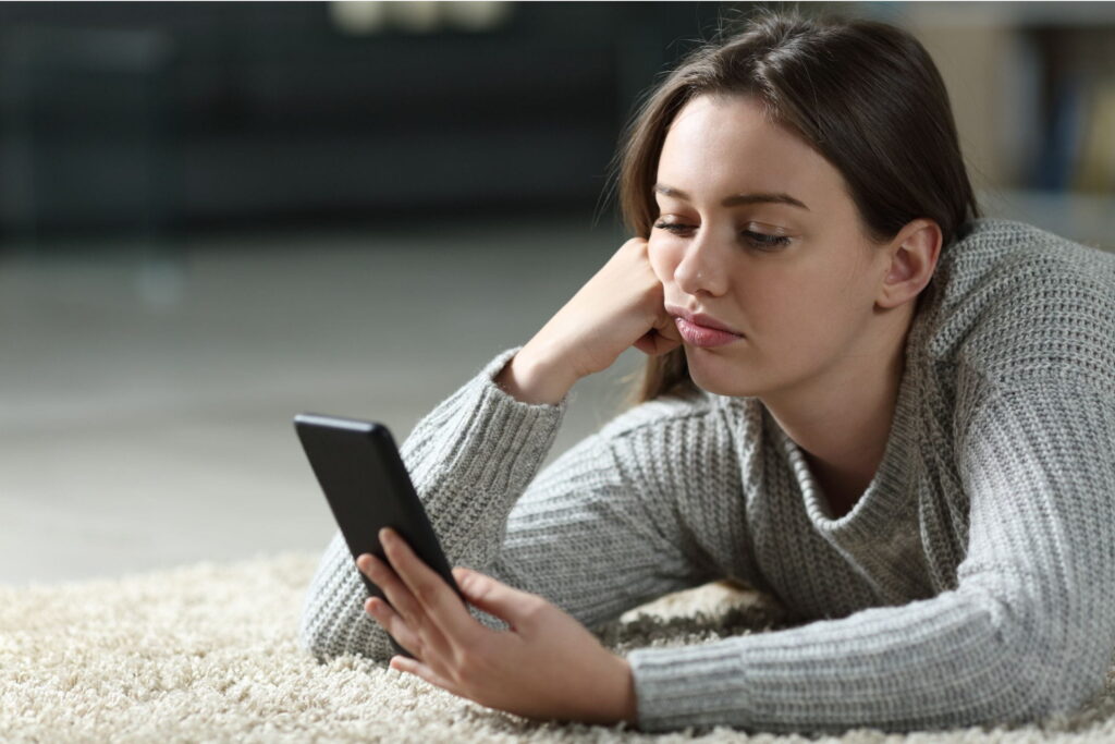 bored teenager who doesn't care about anything stares at phone