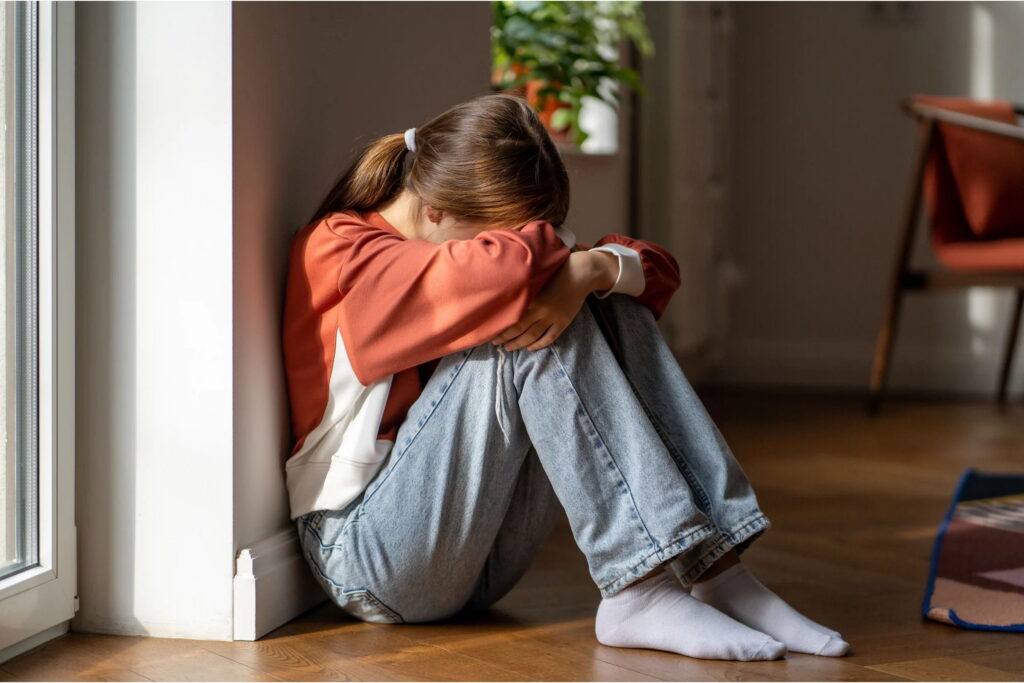 upset teen girl wears long sleeves to conceal cutting scars
